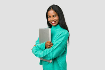 Fototapeta premium Young indian woman holding a laptop isolated on white background