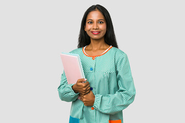 Primary school indian teacher holding books isolated on grey background
