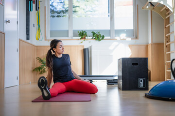 young healthy woman a fit body in a trining centre doing exercise and stretching with red leggings