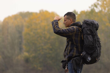 Portrait of traveler man at lake in autumn with a blue and green checkered jacket