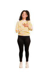 Young african american woman with curly hair cut out isolated laughing keeping hands on heart, concept of happiness.