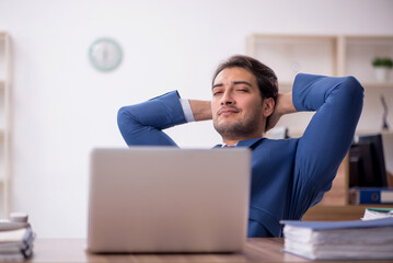 Young male employee unhappy with excessive work in the office
