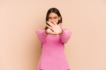 Young colombian woman isolated on beige background standing with outstretched hand showing stop...