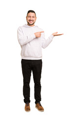 Full body adult latin man cut out isolated excited holding a copy space on palm.