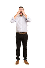 Fototapeta premium Full body adult latin man cut out isolated covers eyes with hands, smiles broadly waiting for a surprise.