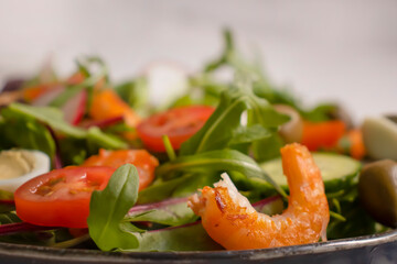 Salad with shrimps, tomatoes in a plate