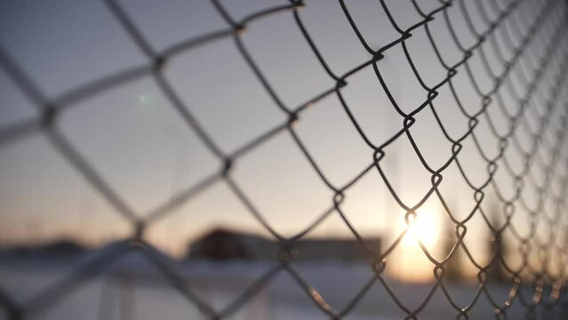 Metallic wire fence with hoarfrost on barren cold winter landscape - camera slowly slide