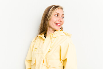 Young caucasian woman isolated on white background looks aside smiling, cheerful and pleasant.