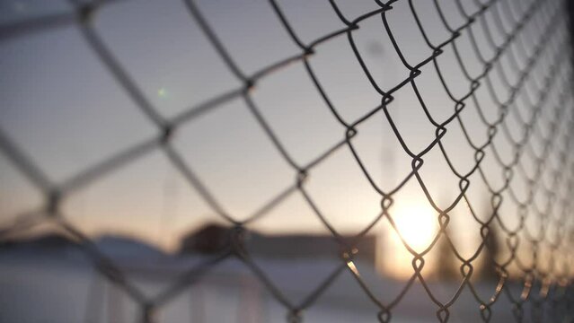 Metallic wire fence with hoarfrost on barren cold winter landscape - camera slowly slide