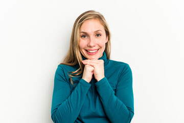 Young caucasian woman isolated on white background keeps hands under chin, is looking happily aside.