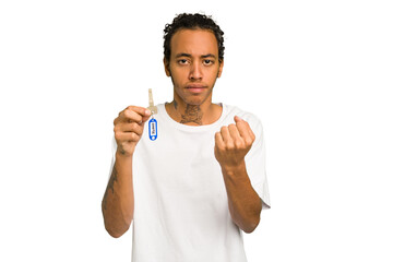 Young African American man holding home keys isolated showing fist to camera, aggressive facial expression.