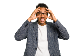 Young African American man isolated keeping eyes opened to find a success opportunity.