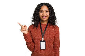 Young african american woman with ID card isolated smiling and pointing aside, showing something at blank space.