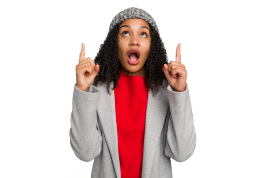 Young african american woman wearing winter jacket isolated pointing upside with opened mouth.