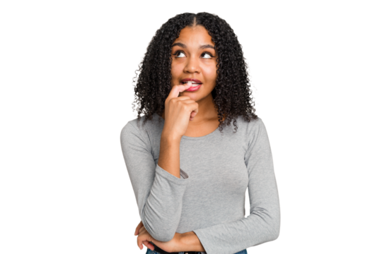 Young african american woman with curly hair cut out isolated looking sideways with doubtful and skeptical expression.
