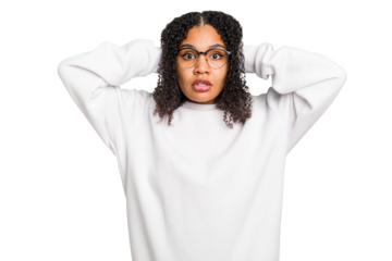 Young african american woman with curly hair cut out isolated covering ears with hands trying not to hear too loud sound.