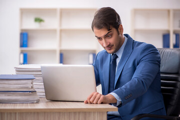 Young male employee and too much work in the office