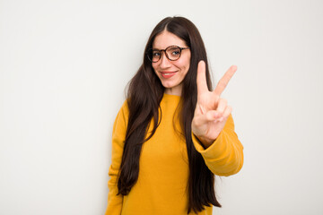 Young caucasian woman isolated on white background joyful and carefree showing a peace symbol with fingers.