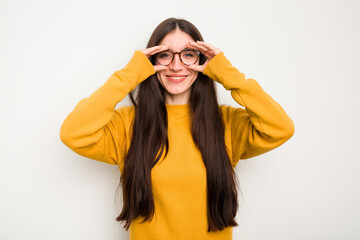 Young caucasian woman isolated on white background showing okay sign over eyes