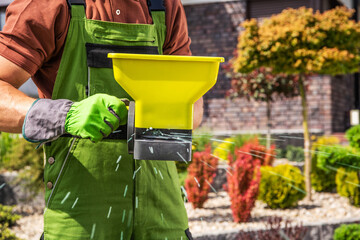 Lawn Fertilization with Handheld Broadcast Spreader Closeup © Tomasz Zajda