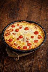 Creamy shortbread pie. Quiche with cherry tomatoes and chicken in the village on a wooden table.