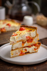 Creamy shortbread pie. Quiche with cherry tomatoes and chicken in the village on a wooden table.