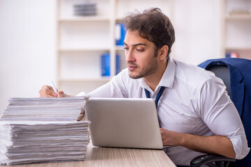 Young male employee and too much work in the office