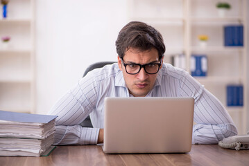 Young male employee and too much work in the office