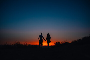 Young couple enjoying sunset in the mountains