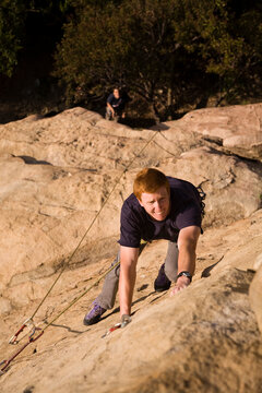 A young male climber works his way the 5.9 crack at Piuma Pinnacle in Malibu, California.