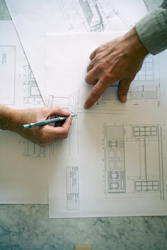 Hands Pointing On A Work Drawing For A New Kitchen