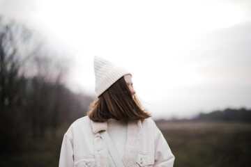 Portrait of a beautiful young woman in warm clothes outdoors