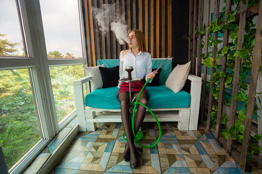 The girl lies on the couch and smokes hookah