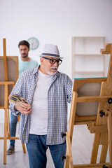 Two male painters enjoying painting at home