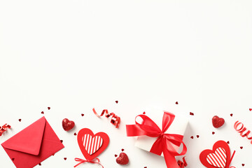 Valentine's Day concept. Frame made of red envelope, gift box, candy, confetti on white background. Valentines day background. Flat lay, view from above.