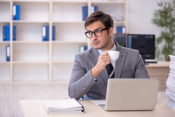 Fototapeta premium Young male employee and too much work in the office