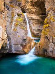 Waterfall and rocks. Long exposure photography. Waterfall and lake. Natural background and wallpaper. Blurry fast water.