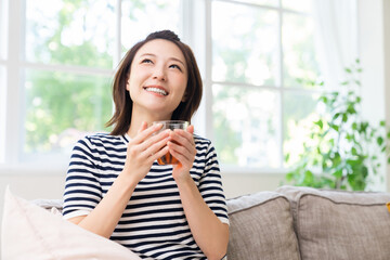 部屋でリラックスする若い女性　飲み物