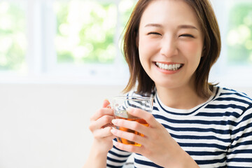 部屋でリラックスする若い女性　飲み物