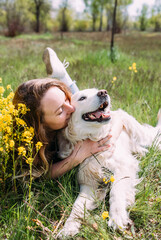 Young beautiful woman and her golden retriever dog having fun in summer