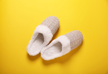 Pair of beautiful soft slippers on yellow background, top view
