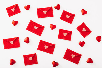 Many felt envelopes with red hearts on white background, top view