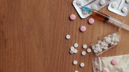 Different hard drugs on wooden table, flat lay. Space for text