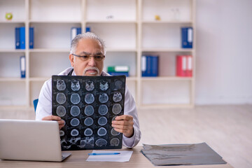 Old male doctor radiologist working in the clinic