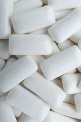 Tasty white chewing gums as background, top view