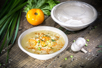 Soup with spaghetti in a disposable bowl