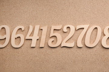 Many wooden numbers on fiberboard, flat lay