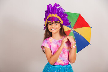 Beautiful Brazilian girl, child, dressed for carnival in Brazil. smiling with frevo umbrella.