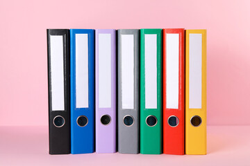 Many hardcover office folders on pink background