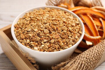 Dried orange seasoning zest and peel on white wooden table, closeup